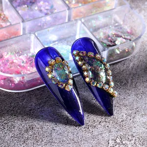 Detail von blauen Stiletto-Nägeln mit Aurora-Glitzer und funkelnden Strasssteinen