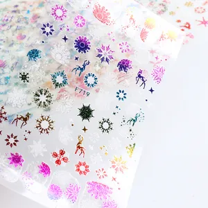 Detail van kerstnagelstickers met kleurrijke laser sneeuwvlokken en rendierpatronen
