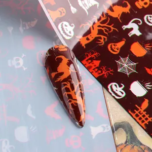 Gros plan de stickers nail art Halloween avec citrouilles, sorcières et araignées