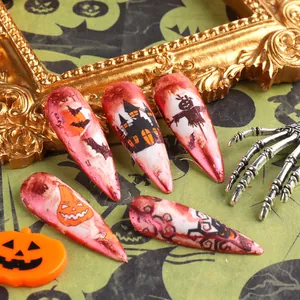 Vue détaillée de faux ongles Halloween stiletto avec motifs de citrouilles et de châteaux