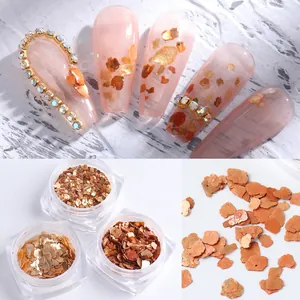 Detailed view of amber and gold nail art foil flakes with irregular marble effects