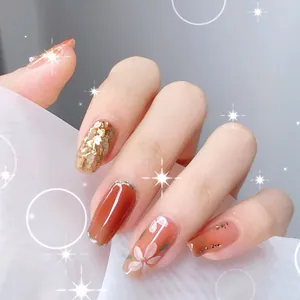 Detail of amber and pink nail art featuring gold leaf, glitter, and floral hand-painted designs