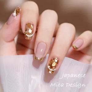 Macro shot of nude pink nails with gold mica flakes, white lines and tiny pearls