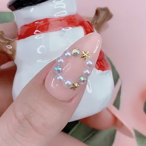 Vista macro de uñas almendradas con corona de perlas y strass sobre base rosa