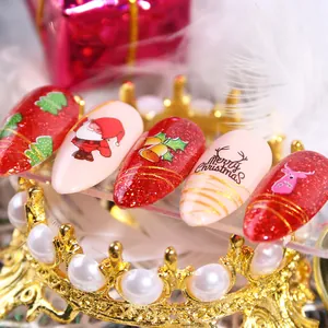 Detail of Christmas nail art stickers with Santa, tree and reindeer on a gold crown display