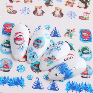 Christmas nail art stickers featuring penguins and polar bears on white manicured nails