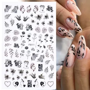 Black vintage line art nail stickers with floral and butterfly patterns on fingers