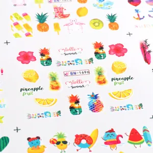 Macro detail of summer nail art stickers featuring tropical fruits and flamingos
