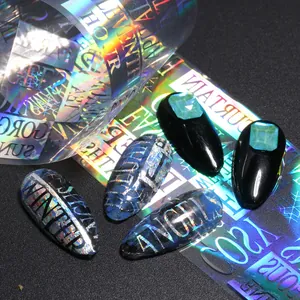 Primer plano de uñas postizas con diseño láser holográfico e incrustación de piedras esmeralda