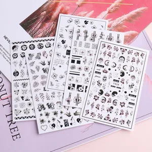 Detail of black and white floral nail art stickers with bees and botanical patterns