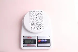 Detailed view of black floral nail art stickers model F811 on an electronic scale