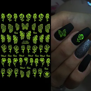 Luminous green rose and butterfly nail stickers glowing on dark matte nails