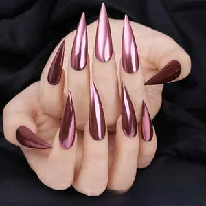 Close-up of rose gold stiletto nails with metallic mirror laser effect on black fabric