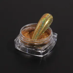 Golden holographic laser nail glitter powder in clear jar on black background