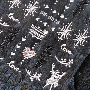 Detailed macro view of 5D embossed heart nail art stickers in white and silver tones