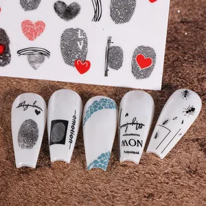 Macro view of 3D nail stickers featuring fingerprint hearts and artistic text patterns