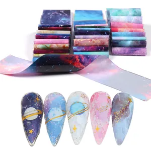Vue macro de feuilles de transfert nail art cosmique avec motifs de galaxie variés