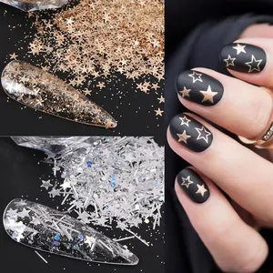 Macro view of gold and silver star nail sequins applied on matte black manicure nails