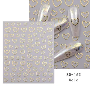 Detailed view of SO-163 3D gold heart nail stickers with application on fingernails