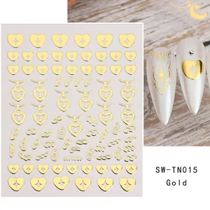 Detailed view of 3D gold heart nail stickers with metallic line patterns on white nails