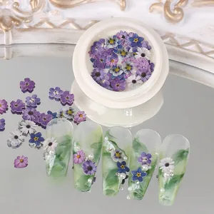 Detailed view of floral wood pulp chips on manicured nails with green marble texture