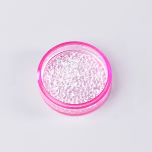 Close-up of sparkling clear rhinestones in a pink translucent plastic storage container
