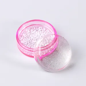 Macro detail of French nail stamper kit featuring pink container and sparkling glitter cap