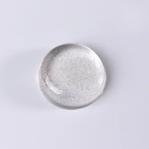 Macro shot of a transparent silicone nail stamper head with colorful glitter sparkles
