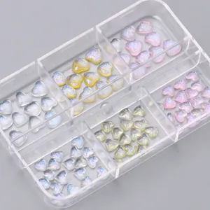 Macro shot of colorful aurora heart-shaped nail art glitters in a six-grid storage box