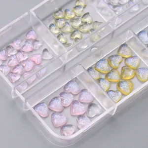 Macro detail of aurora glitter heart nail art charms stored in a clear organizer box