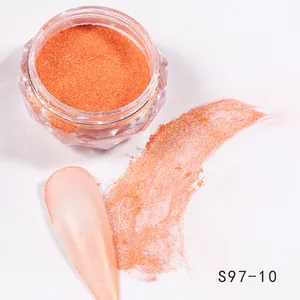 Macro detail of vibrant orange metallic nail glitter powder in a diamond-shaped jar