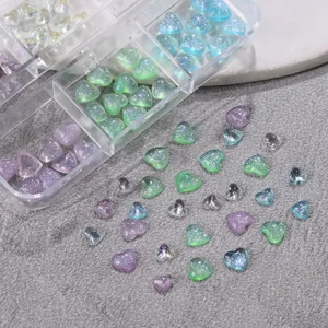 Macro view of colorful glitter heart-shaped nail art charms in a transparent storage box