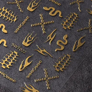 Detalle macro de pegatinas 3D doradas para uñas con diseños de serpiente y cadena