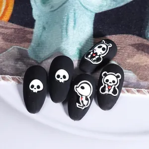 Dettaglio macro di adesivi per unghie Halloween 3D con teschi cartoon nero opaco