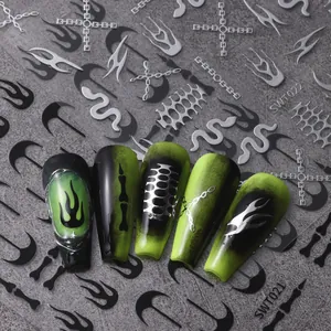 Detalle macro de pegatinas 3D punk para uñas con patrones de llamas y cadenas