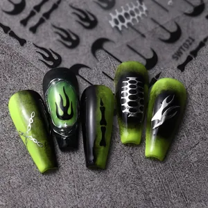 Vista macro de uñas largas con degradado negro y verde, cadenas de plata y llamas en 3D
