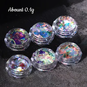Macro view of 6 jars containing iridescent and laser nail glitters on grey background