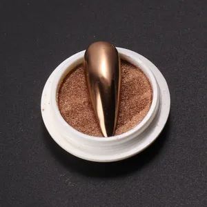 Détail de la poudre à ongles miroir or rose dans un pot rond avec ongle de démonstration