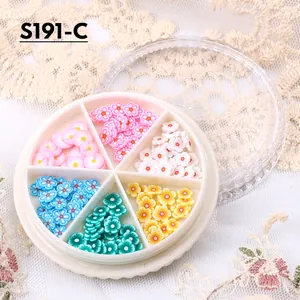 Dettaglio di fiori colorati in pasta polimerica 3D per nail art in una scatola a sei scomparti