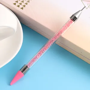 Close-up of dual-head nail dotting tool with wax tip and crystal-filled handle