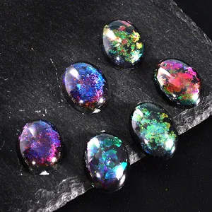 Macro view of six aurora chameleon oval sequins on a dark textured rock background