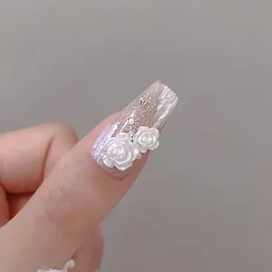 Detail of 3D matte white resin roses and pearls on long square press-on nails