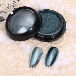 Vue macro d'une poudre à ongles chrome vert foncé avec effet miroir métallique