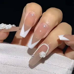 Macro shot of long coffin press-on nails with 3D camellia flowers and pearl accents