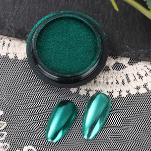 Macro shot of emerald green mirror nail powder with metallic chrome finish on swatches