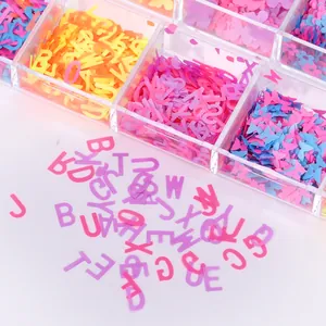 Colorful alphabet and butterfly nail art sequins set in a transparent storage box