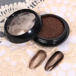 Gros plan de poudre à ongles chrome bronze avec échantillons effet miroir sur dentelle