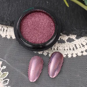 Detailed view of pink holographic nail mirror powder in jar with swatches on dark stone