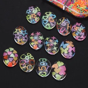 Macro view of transparent oval cabochons with colorful stars and heart shapes