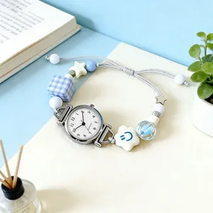 Women's quartz bracelet watch with blue beads and adjustable drawstring strap on desk